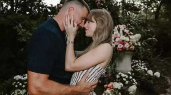 Taylor Swift holding Travis’s face in her hands
